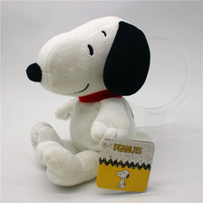 A white Snoopy plush toy with black ears and a red collar sitting on a clear stand.
