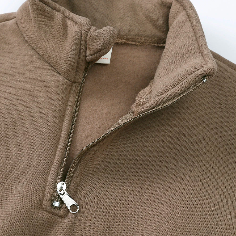 Close-up of a brown fleece hooded jacket with a zipper detail.