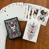 A deck of black and white poker cards is displayed next to a stylized tarot card.