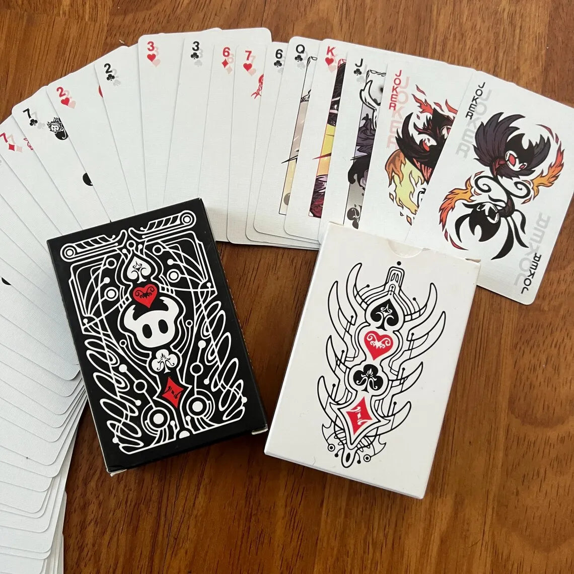 A deck of black and white poker cards is displayed next to a stylized tarot card.