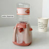 A pink water dispenser device with a glass cup is shown on a white surface.