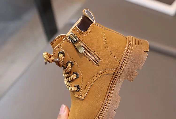 A close-up view of a tan kids' winter leather boot with laces and a side zipper.