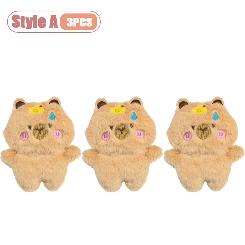 Three cute tan capybara plush toys used as keychains or bag charms