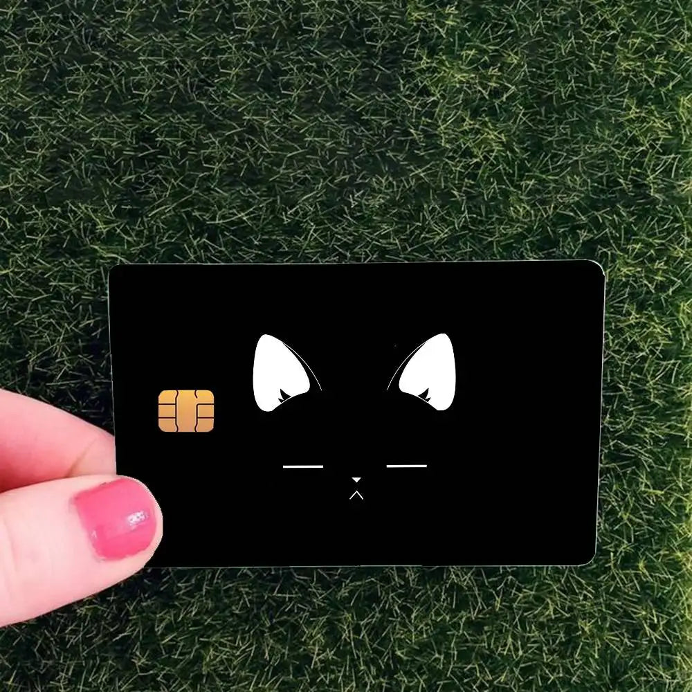 A black card with a cat face design featuring white eyes and a thumbs-up hand gesture