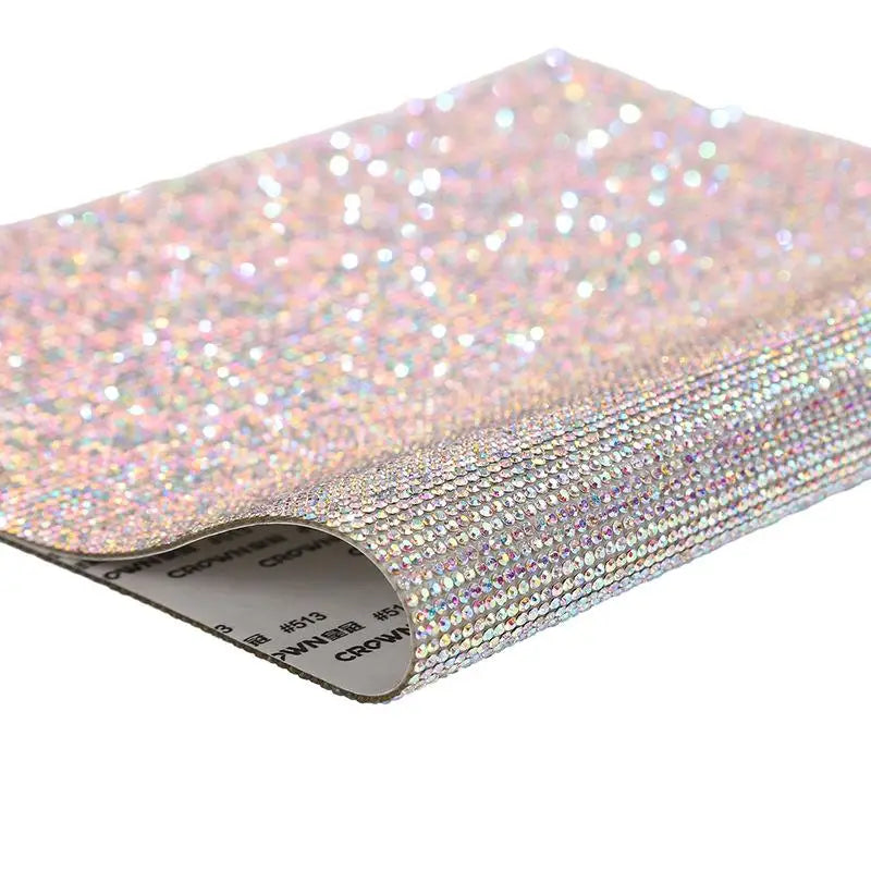 Close-up of iridescent pink sparkling rhinestone adhesive tape rolled up for DIY crafts