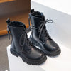 A pair of black girls' ankle boots with laces and an anti-skid rubber sole displayed on a white surface.