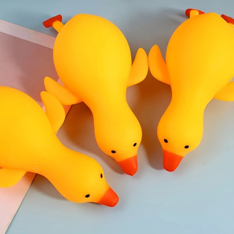 A bright yellow squishy duck fidget toy is shown against a light blue background.