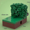 A green MOC building block set depicting a figure in bushes on a brown base.