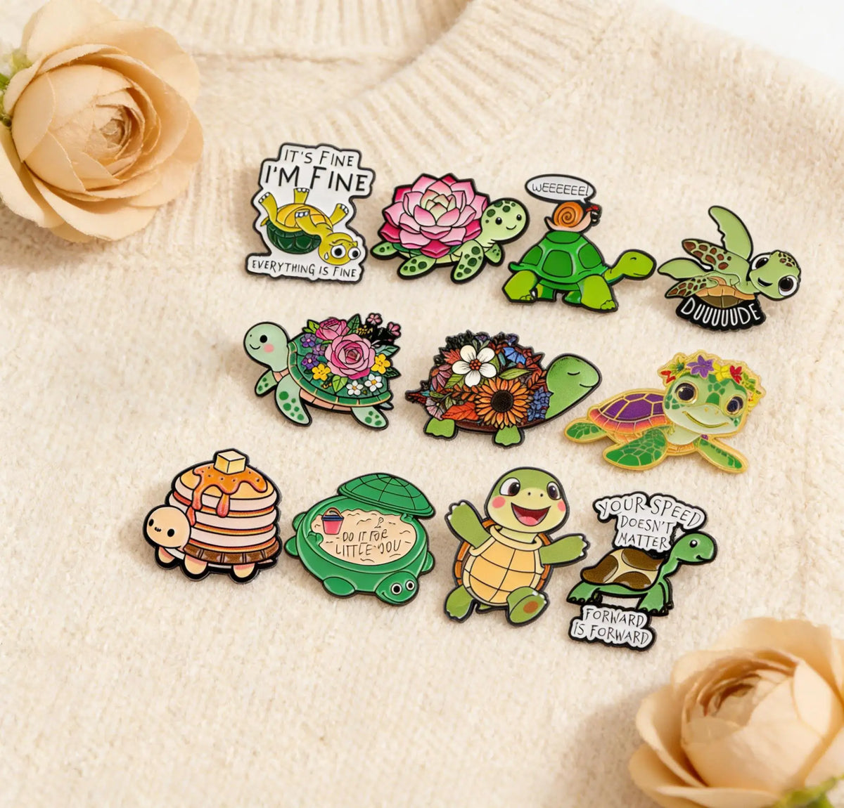 A set of cute green turtle enamel pins featuring various designs and sayings on a light sweater.