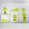 A collection of lime green glow-in-the-dark elf figures displayed on white circular stands.