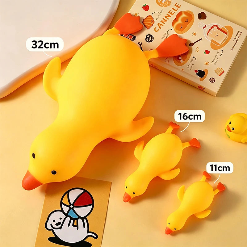 A yellow squishy toy shaped like a duck is shown next to a book and a card.