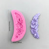A pink silicone mold shaped like a flower is shown next to a purple floral silicone mold.