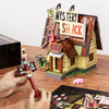 A wooden building block set depicting a mystery shack scene with various structures and accessories.