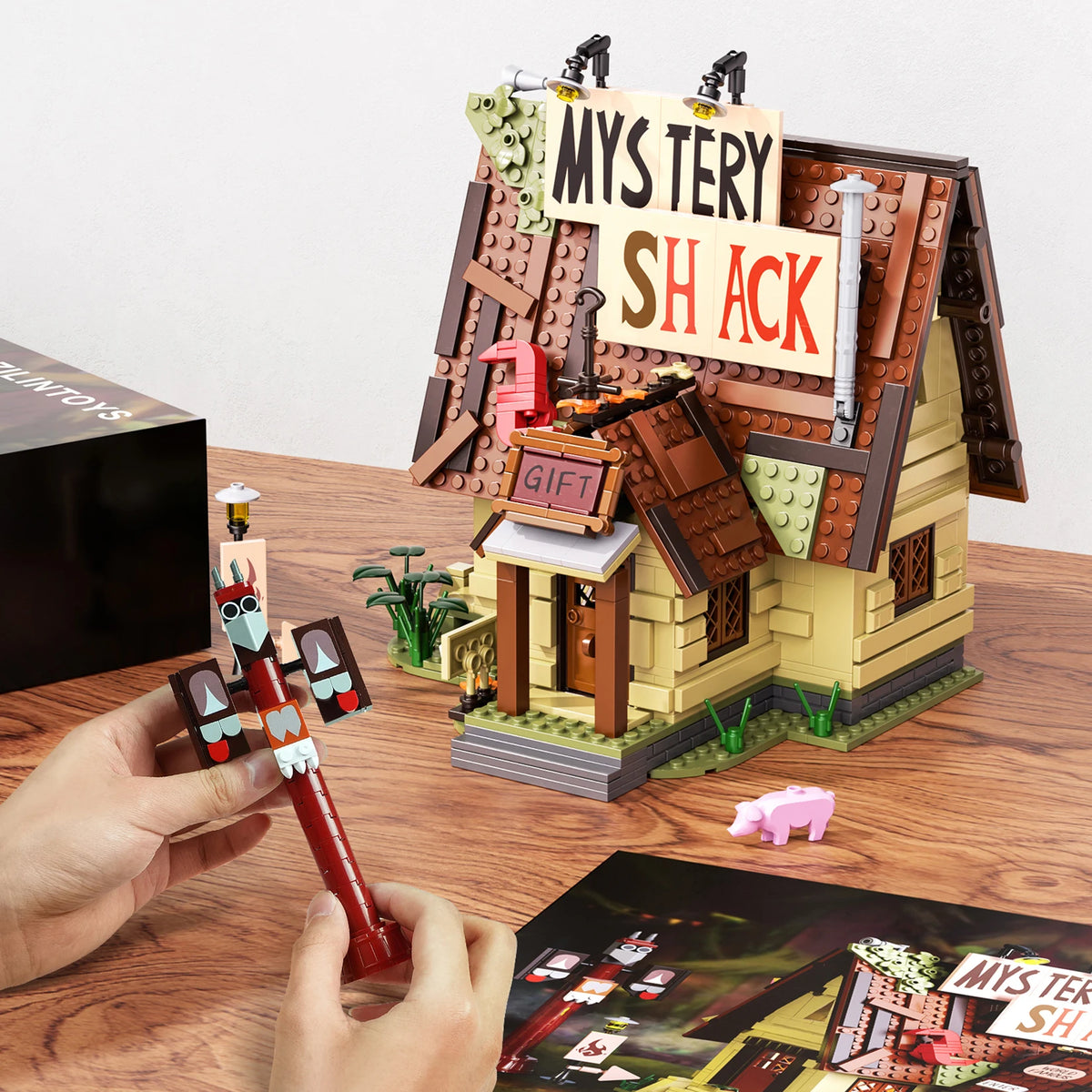 A wooden building block set depicting a mystery shack scene with various structures and accessories.