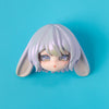 A light purple and white stylized doll with long hair and large blue eyes is shown against a bright blue background.