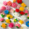 A collection of multi-colored silicone flower molds in various shades of pink, orange, yellow, and red.