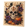 A framed canvas featuring a detailed skull design adorned with pearls, autumn leaves, and small pumpkins.