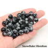 A handful of black snowflake obsidian round beads for jewelry making