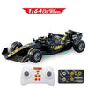 A black 1:64 scale RC drift car model with wheels and a white controller and battery.