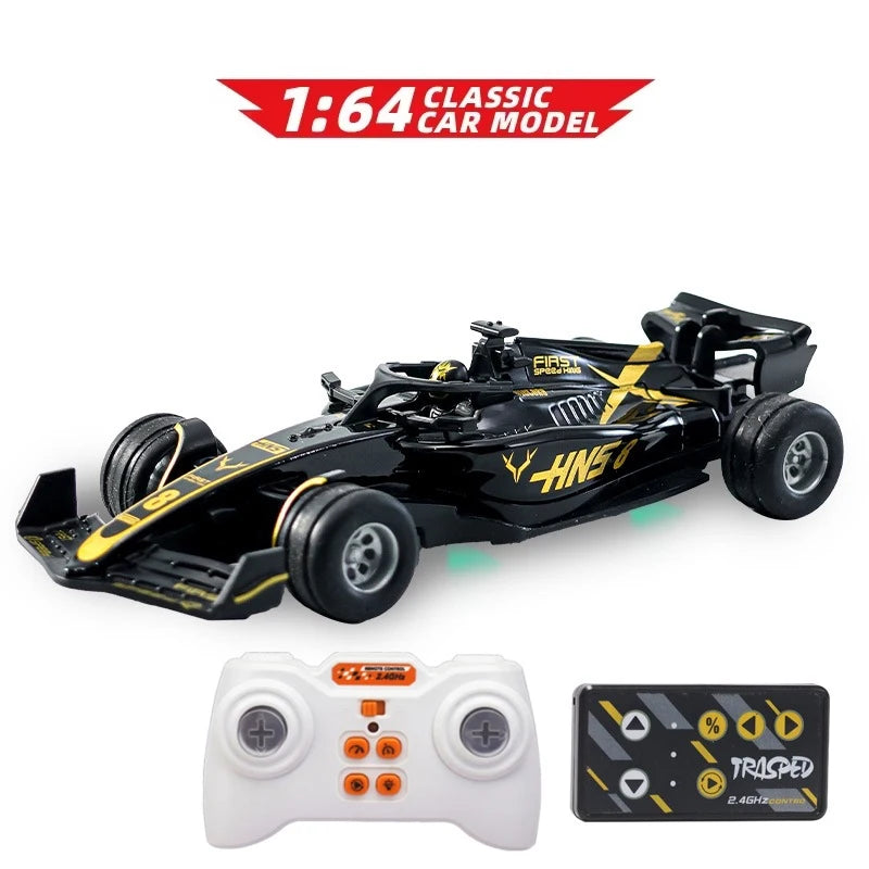 A black 1:64 scale RC drift car model with wheels and a white controller and battery.