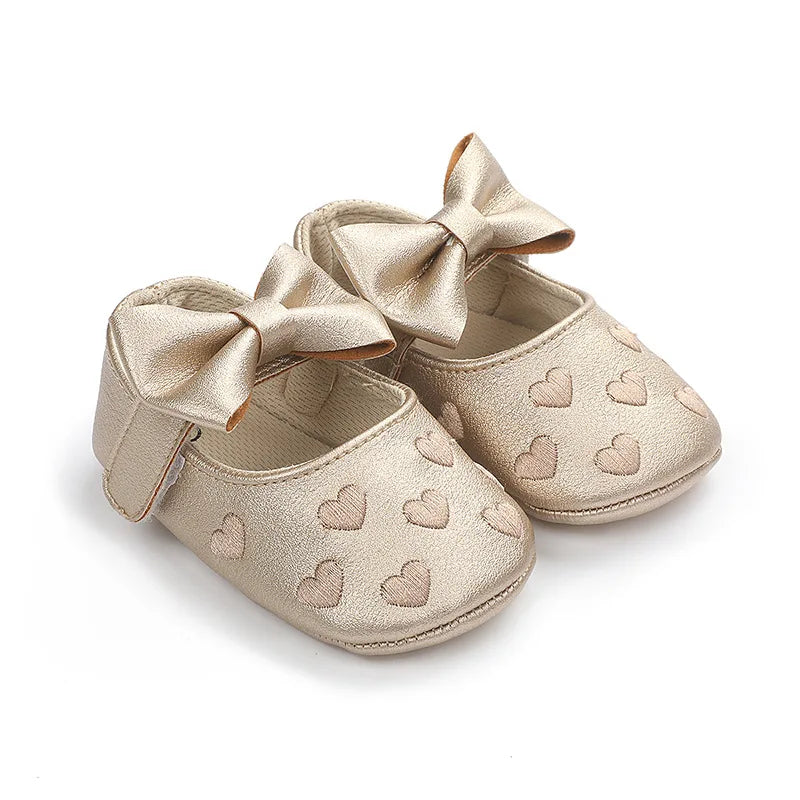 Pair of gold glitter baby girl shoes with bow knots and a soft anti-slip sole