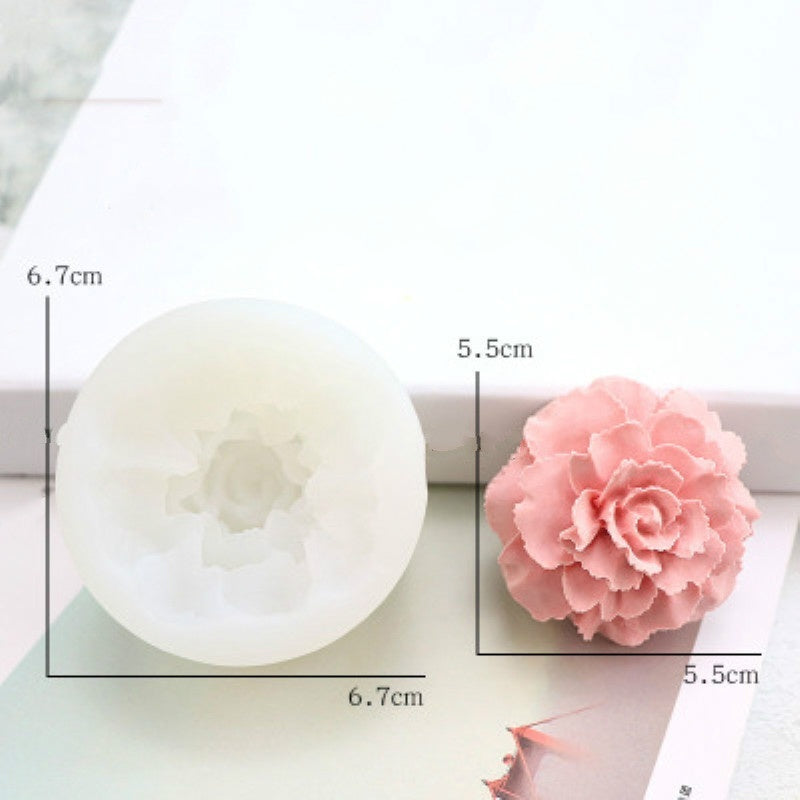 A white silicone mold shaped like a pink flower, used for decorating soap, candles, or cakes.