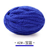 A ball of deep blue chunky chenille yarn used for hand knitting projects.