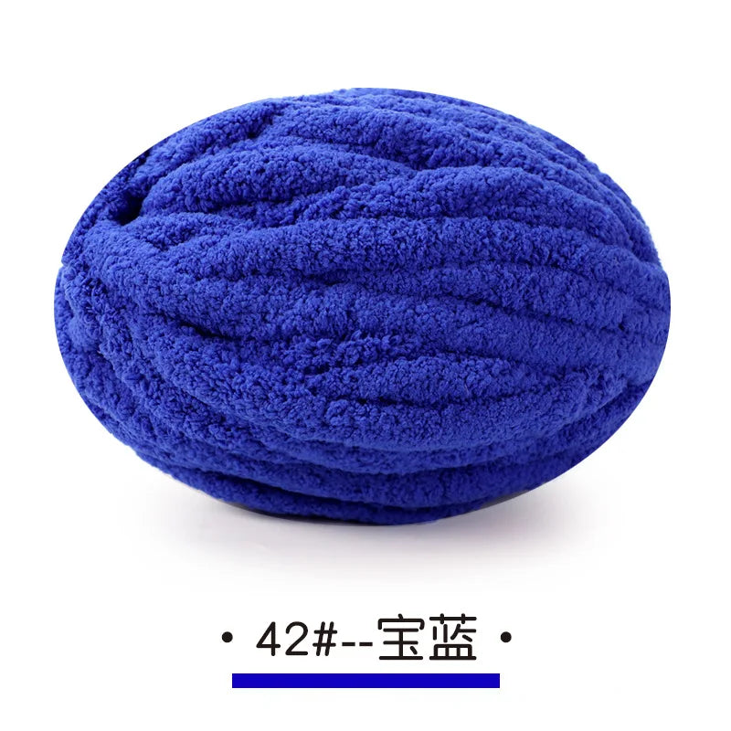A ball of deep blue chunky chenille yarn used for hand knitting projects.