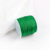 A roll of bright green 0.8mm cotton nylon macrame cord for jewelry making and crafts.