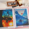 A transparent diamond painting storage album displaying two colorful finished paintings.