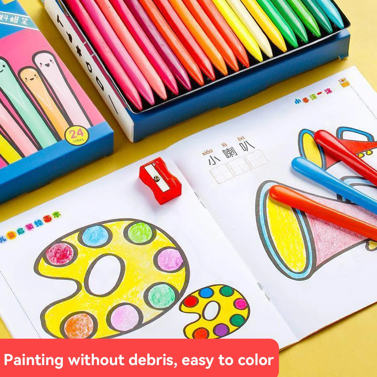 A set of triangular colored crayons in a blue box and an open notebook showing colorful drawings.