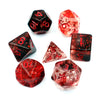 A set of red and clear crystal style polyhedral dice scattered on a white background.