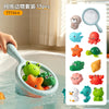 A hand is holding a silicone bath toy set of 13 plastic sea creatures and a fishing net in water.