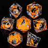 A set of ten translucent orange and black liquid core resin dice arranged on a reflective surface.