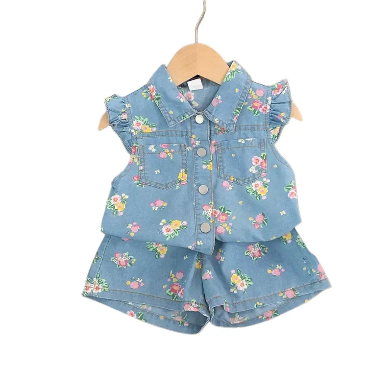 A girl's floral print sleeveless shirt and shorts set in blue denim fabric.