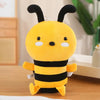 A yellow and black striped handmade bee plush toy with large eyes sitting on a wooden surface.