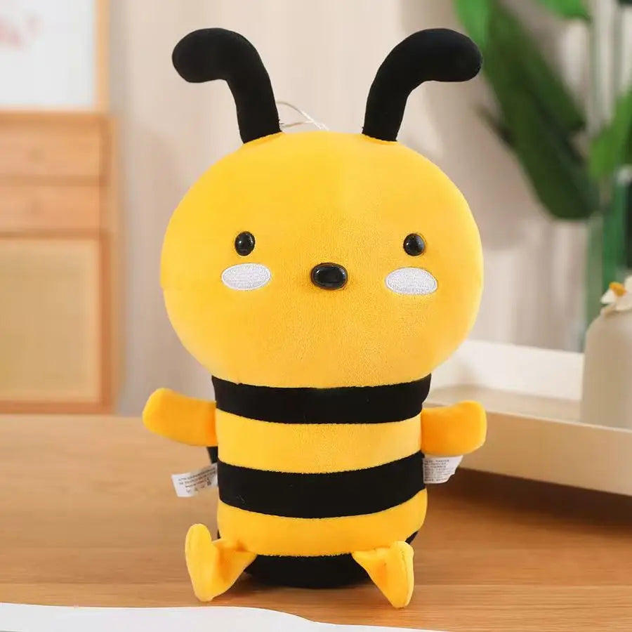 A yellow and black striped handmade bee plush toy with large eyes sitting on a wooden surface.