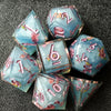 A collection of light blue resin polyhedral dice featuring pink floral accents.