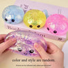 A collection of colorful squishy glitter fidget toys shaped like buns are displayed on a book.