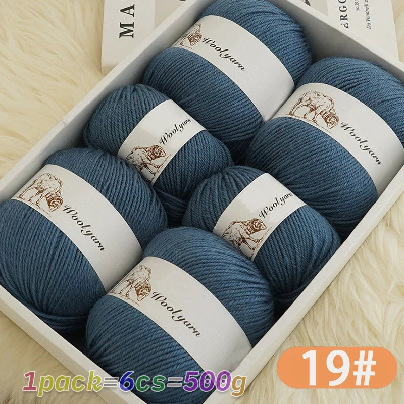 A box of 6 balls of blue wool yarn for knitting, labeled Woolyarn, resting on a light surface.