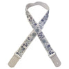 A beige woven guitar strap with blue floral patterns and leather accents.