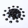 A scattered pile of clear glass crystal hot fix rhinestones for DIY crafts and decor.