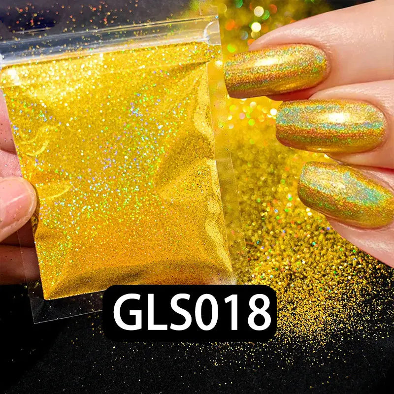 A hand holds a small plastic bag of bright yellow holographic glitter dust next to some applied nail polish.