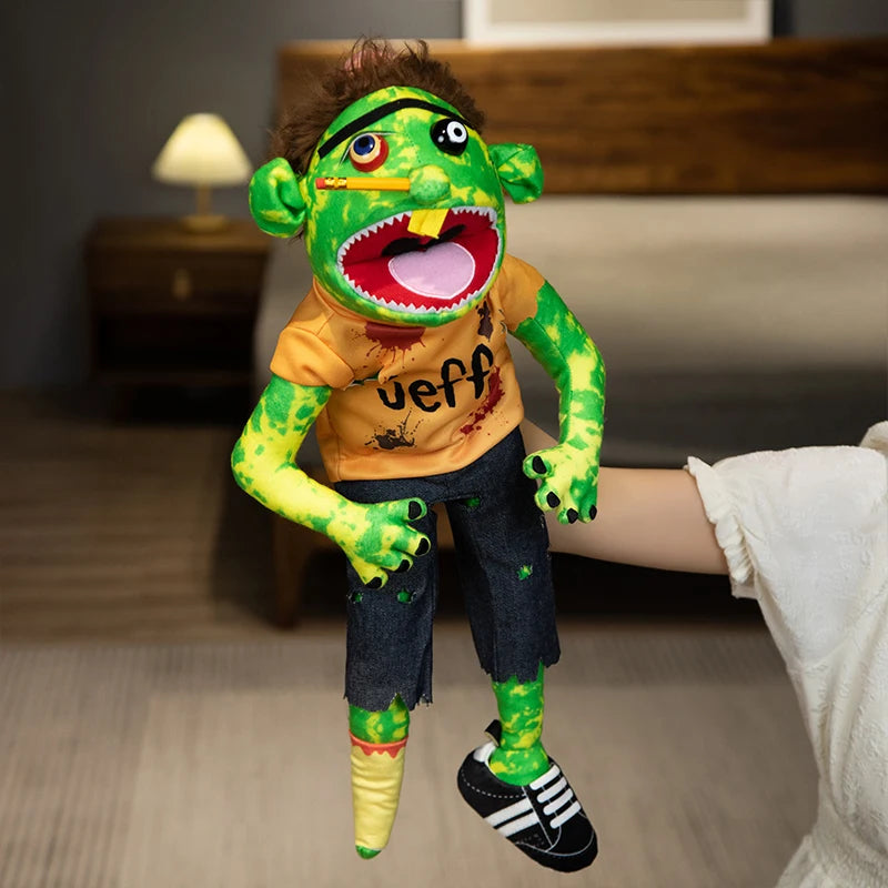 A realistic plush hand puppet resembling a green monster with large teeth and bright yellow skin.