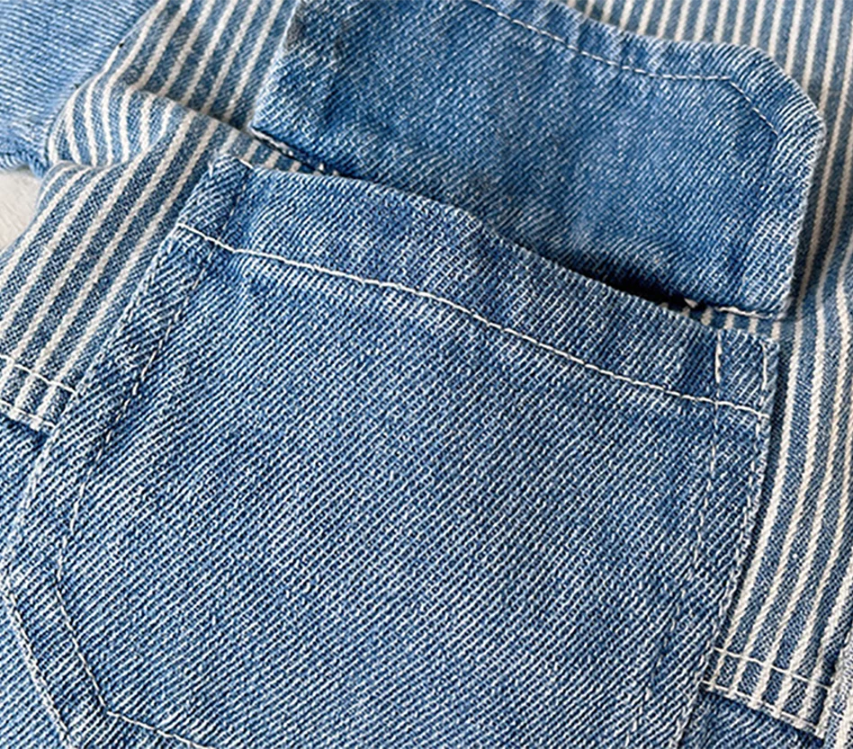 Close-up of a blue denim jacket showing a pocket detail and striped fabric texture.