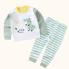 A white and green cartoon cotton pajama set for a child featuring a dinosaur design.