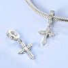 A sterling silver cross pendant and chain with charm beads shown against a light blue background.