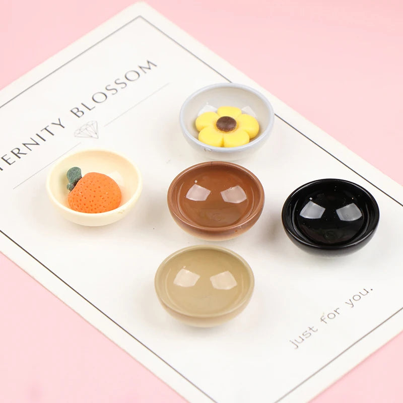 A set of ten miniature dollhouse rice bowls in various earthy and yellow tones displayed on a white card.
