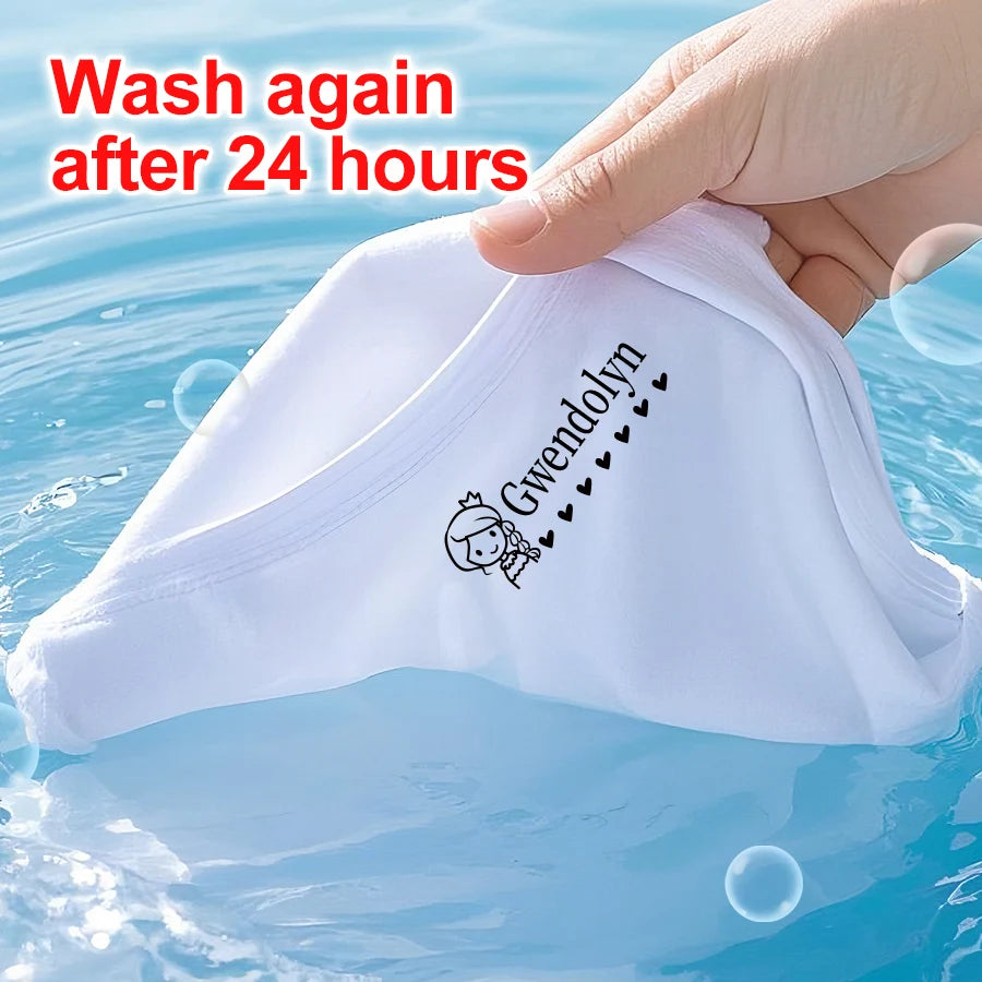 A white waterproof labeling stamp with the name Gwendolyn is being held over water.