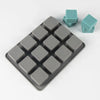 A square silicone soap mold with 12 cavities is shown, featuring gray and teal colored silicone pieces.